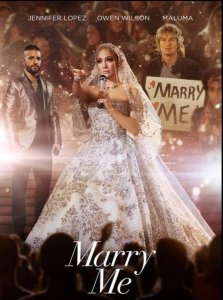 Jennifer Lopez in a wedding dress and veil holding a microphone and pointing toward an audience. Behind her are Maluma in a silver metallic jacket and Owen Wilson holding a sign that says Marry Me. Above it says JENNIFER LOPEZ, OWEN WILSON, MALUMA. Below it says Marry Me.