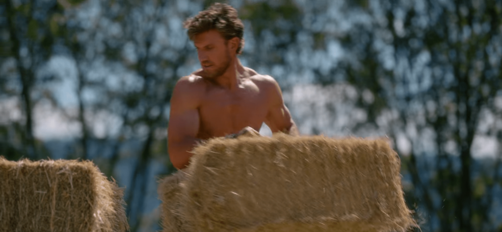 Max, shirtless, moving haybales.
