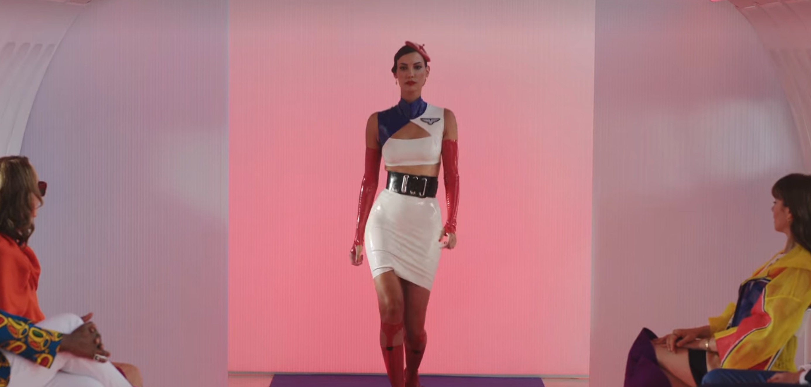 A model walking in a flight attendant uniform made of latex and