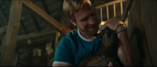 The road guy holding a baby goat.